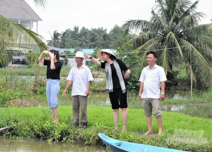 Bà Nguyễn Thị Hằng (thứ 2 từ phải sang), Tổng Giám đốc Công ty Cổ phần Tập đoàn Thủy sản Bồ Đề cùng nông dân huyện An Minh tham quan, đánh giá hiệu quả mô hình dụng sản phẩm sinh học Bồ Đề Mother Water xử lý môi trường nước trong mô hình tôm - lúa. Ảnh: Trung Chánh