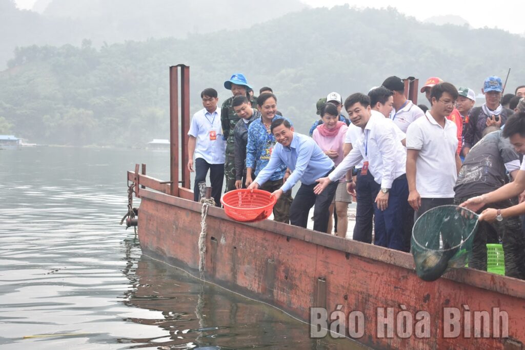 Các đại biểu tham gia thả cá giống tái tạo nguồn lợi thuỷ sản tại vịnh Ngòi Hoa (Tân Lạc)